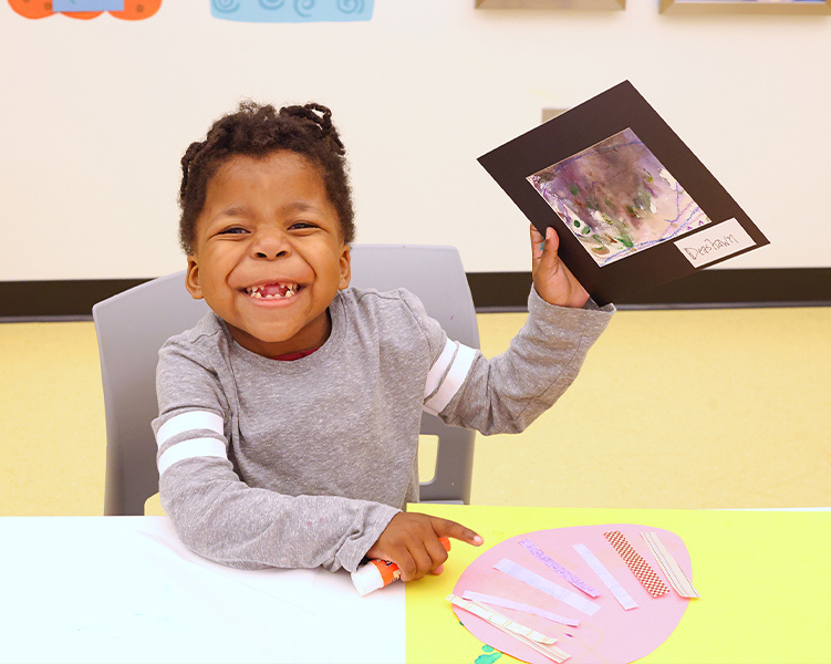 Patient Deshawn holding a piece of art he created.
